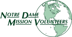 Notre Dame Mission Volunteers in front of a green and white globe